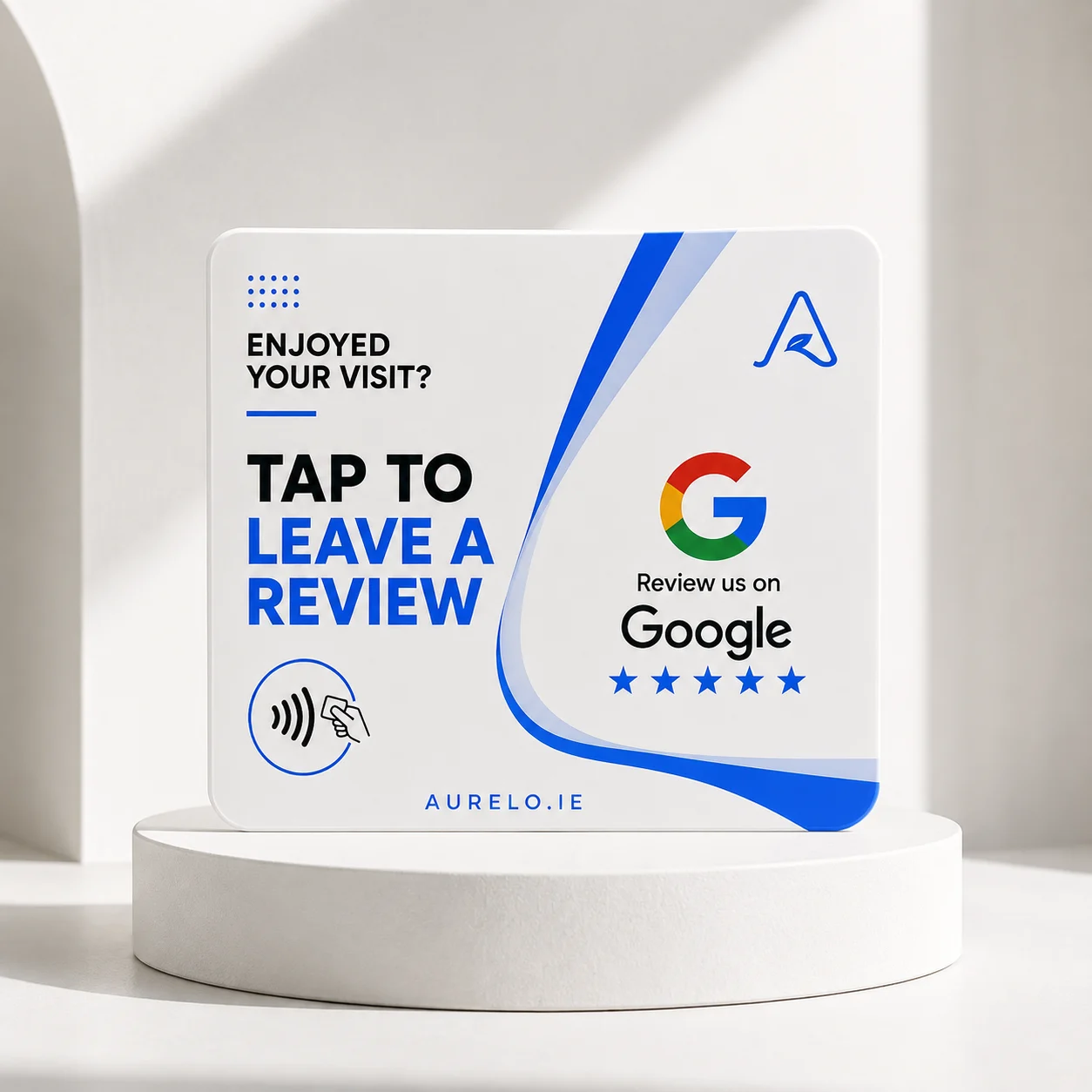 An aurelo NFC review card standing on a plinth, lit in a studio: “Enjoyed your visit? Tap to leave a review”, the Google Reviews mark and five stars.